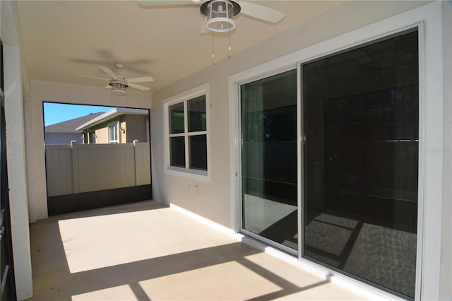 unfurnished sunroom featuring ceiling fan