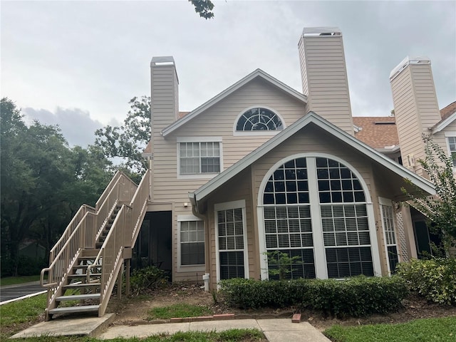 rear view of house with a chimney and stairs