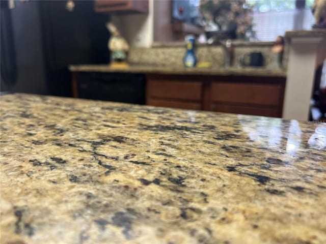 kitchen featuring freestanding refrigerator and light stone counters