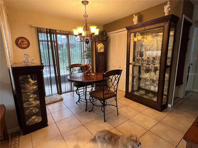 dining area featuring a notable chandelier, light tile patterned floors, and a textured ceiling