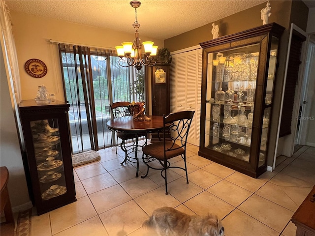 dining room with light tile patterned flooring, a textured ceiling, and an inviting chandelier