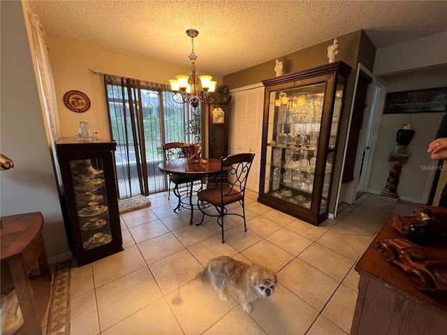 dining space featuring light tile patterned floors, an inviting chandelier, and a textured ceiling