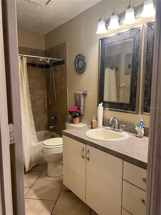 bathroom featuring toilet, a textured ceiling, shower / bath combo with shower curtain, vanity, and tile patterned floors