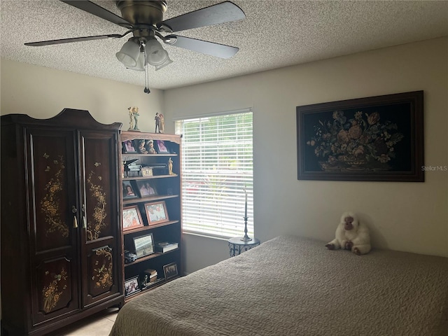 bedroom featuring multiple windows, a textured ceiling, and ceiling fan