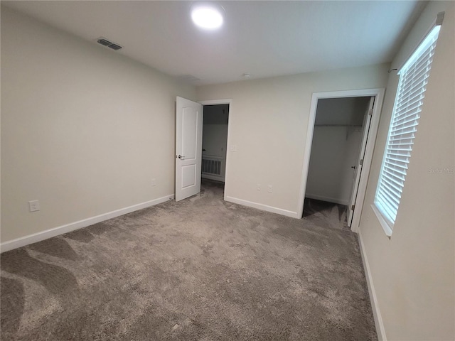 unfurnished bedroom featuring a closet, multiple windows, and carpet flooring