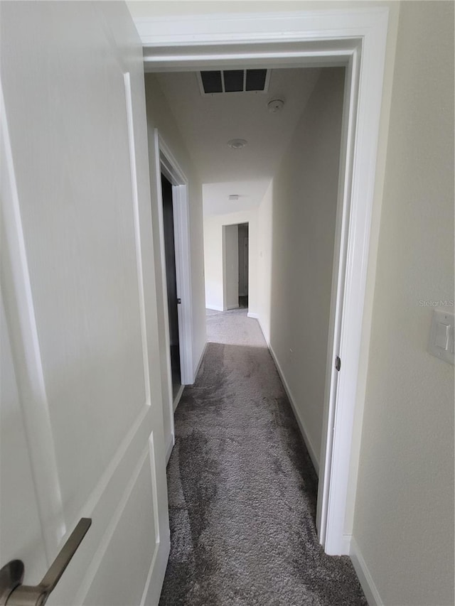 corridor featuring dark carpet