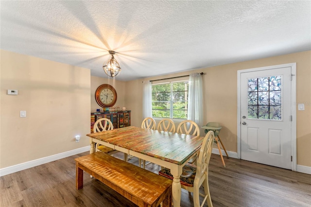 dining area with a textured ceiling, hardwood / wood-style floors, and plenty of natural light