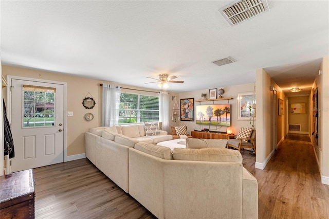 living room with ceiling fan, hardwood / wood-style flooring, and a healthy amount of sunlight