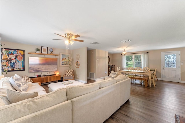 living room featuring dark wood-type flooring and ceiling fan