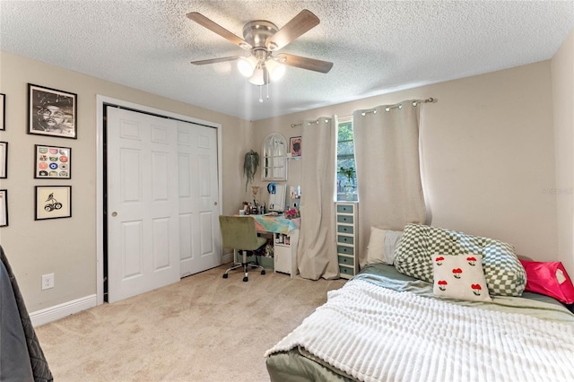 carpeted bedroom with ceiling fan, a textured ceiling, and a closet