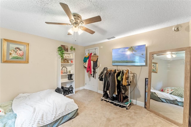 carpeted bedroom featuring a textured ceiling and ceiling fan