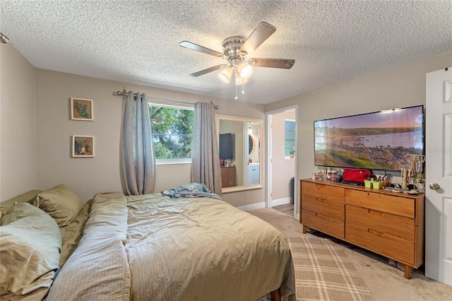 carpeted bedroom with ceiling fan and a textured ceiling