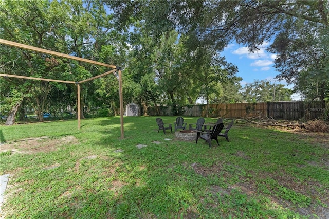 view of yard featuring a storage shed and an outdoor fire pit