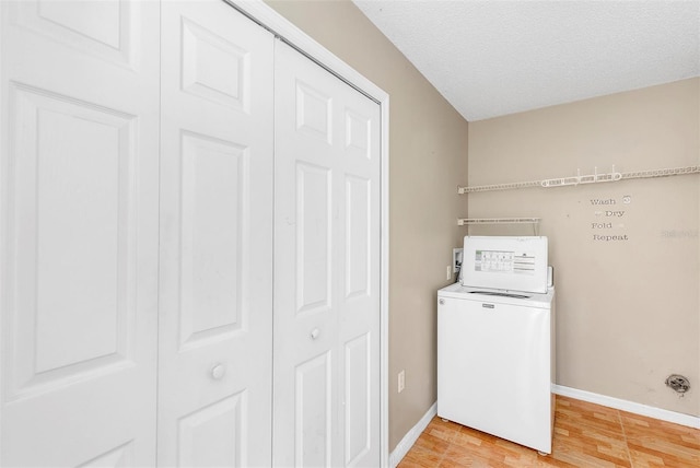 laundry area featuring wood-type flooring, washer / clothes dryer, and a textured ceiling