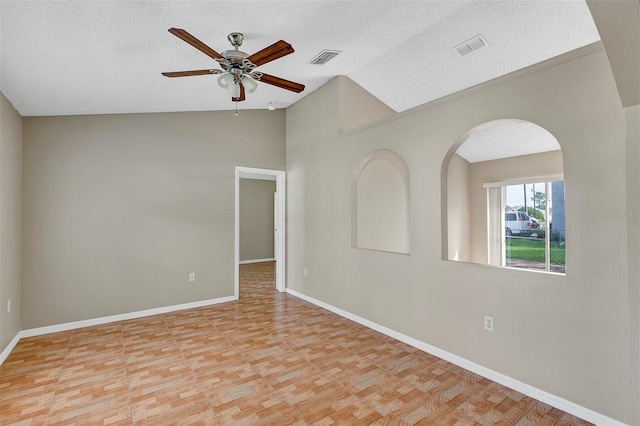 spare room featuring ceiling fan, a textured ceiling, lofted ceiling, and light hardwood / wood-style flooring