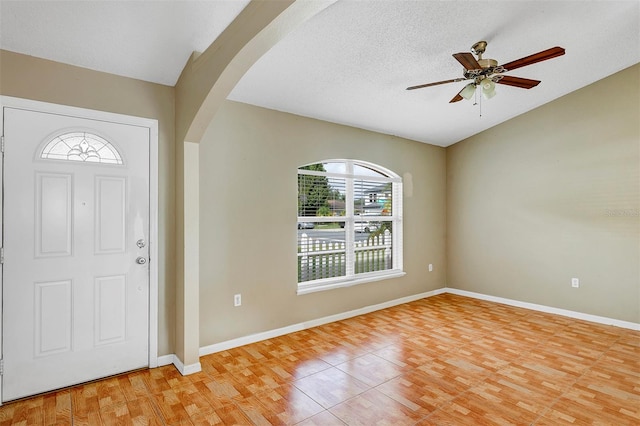 foyer featuring wood-type flooring, a textured ceiling, and ceiling fan