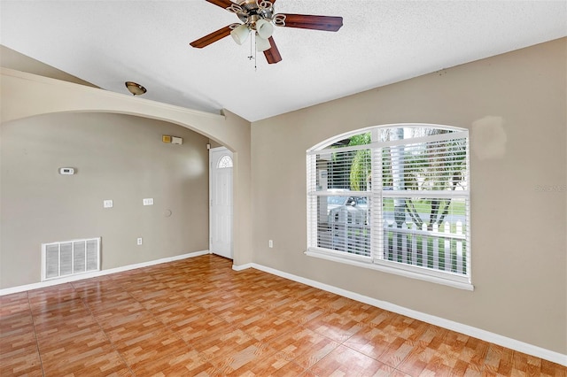 spare room featuring ceiling fan, hardwood / wood-style flooring, lofted ceiling, and a textured ceiling