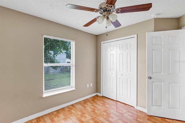 unfurnished bedroom featuring ceiling fan, a textured ceiling, and light hardwood / wood-style flooring