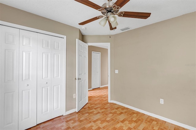 unfurnished bedroom with ceiling fan, a textured ceiling, and light wood-type flooring