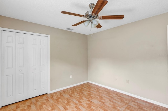 unfurnished bedroom featuring a closet, light hardwood / wood-style floors, ceiling fan, and a textured ceiling