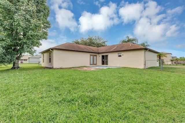 rear view of property featuring a lawn and a patio area