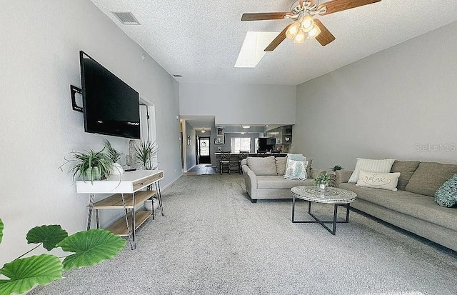 carpeted living room featuring ceiling fan and a textured ceiling