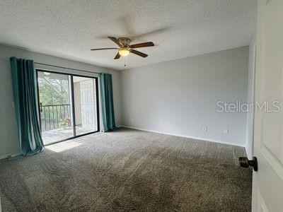 carpeted spare room featuring a textured ceiling and ceiling fan