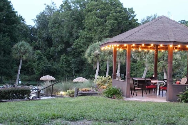 view of community with a gazebo, a lawn, and a patio