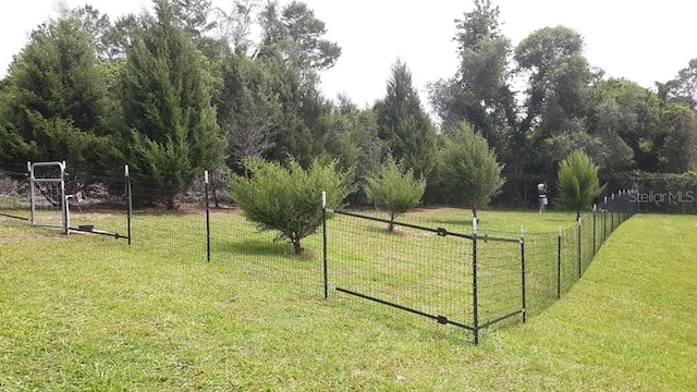 view of property's community with a gate, fence, and a lawn