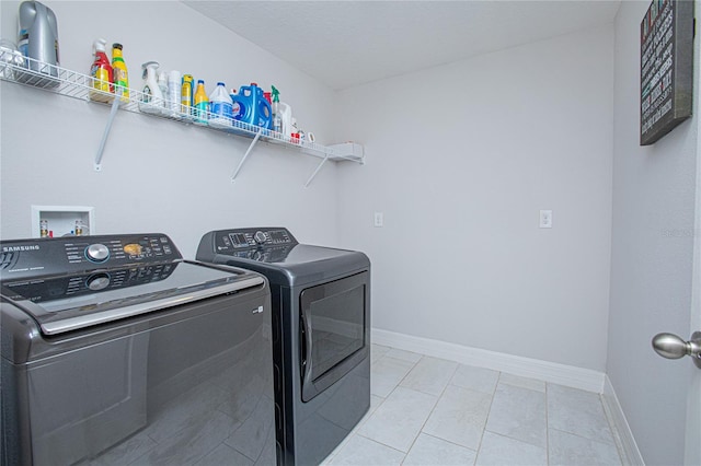 washroom with light tile patterned floors and washer and dryer