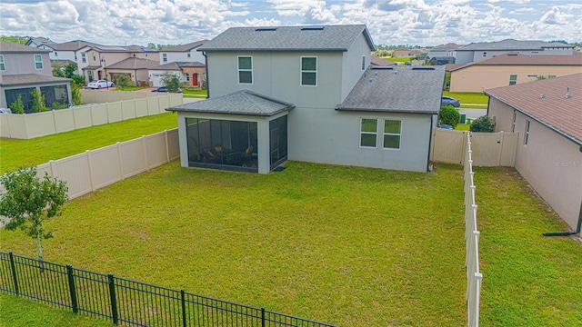 back of property with a lawn and a sunroom