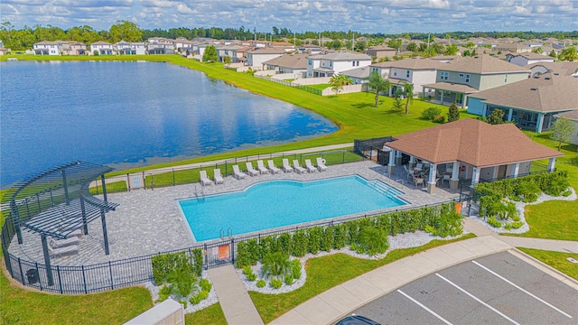 view of pool featuring a patio, a lawn, and a water view