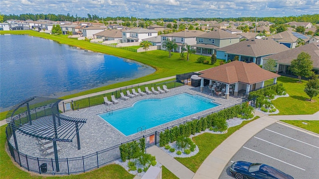 view of pool featuring a water view, a yard, and a patio area