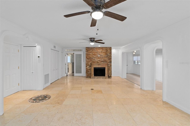 unfurnished living room featuring ceiling fan and a large fireplace