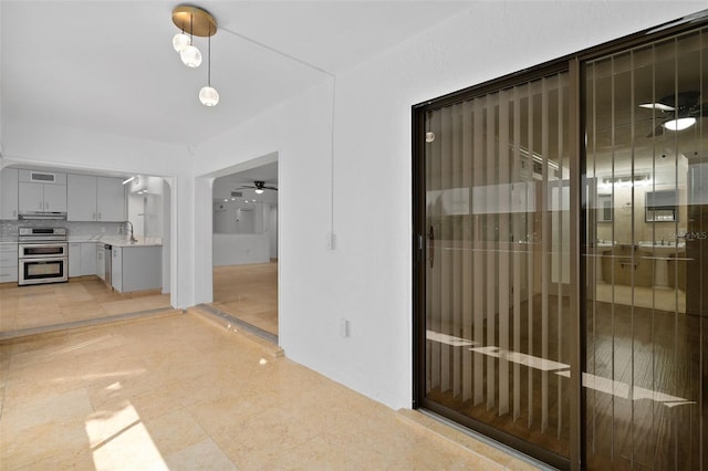 interior space featuring ceiling fan and sink