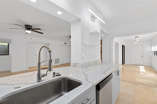 kitchen with light stone counters, ceiling fan, sink, stainless steel dishwasher, and crown molding