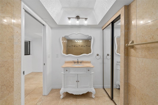 bathroom featuring tile patterned floors, a textured ceiling, and vanity