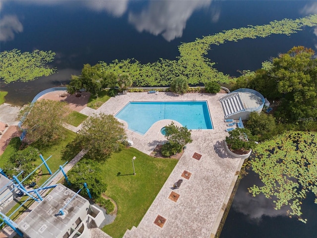 view of pool with a yard, a water view, and a patio area