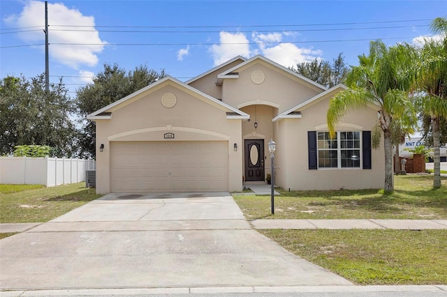 view of front of house with a garage, central AC unit, and a front lawn