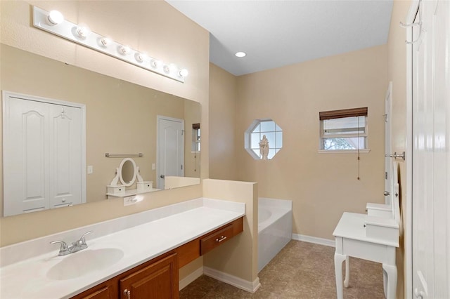 bathroom with a bathing tub, vanity, and tile patterned floors