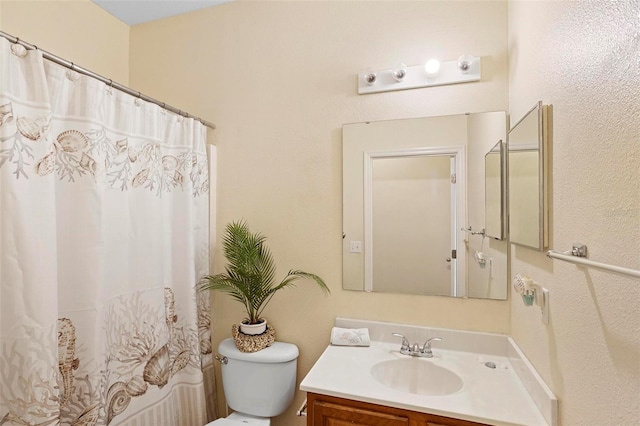 bathroom featuring a shower with curtain, vanity, and toilet