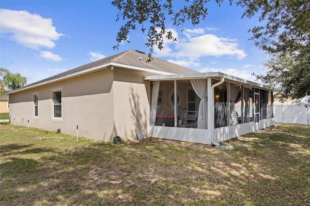 rear view of property featuring a sunroom and a yard