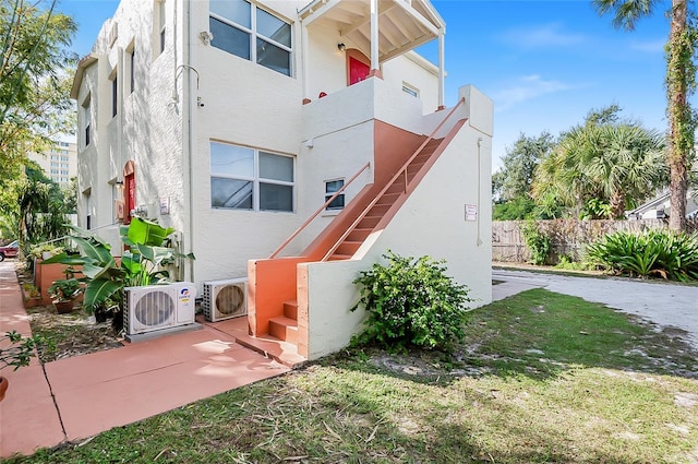 view of home's exterior with a patio, a yard, and ac unit