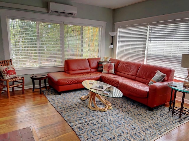 living room with hardwood / wood-style flooring, an AC wall unit, and plenty of natural light