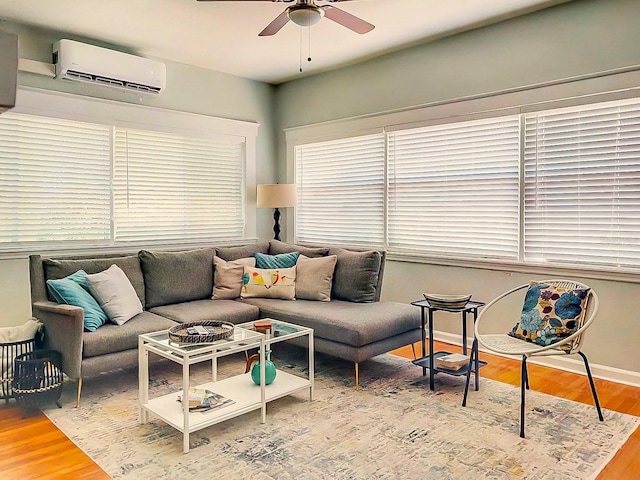 living room featuring ceiling fan, plenty of natural light, hardwood / wood-style floors, and a wall mounted air conditioner