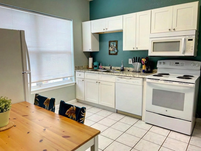 kitchen featuring light tile patterned floors, sink, white appliances, and white cabinetry