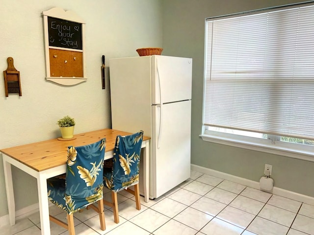 kitchen with light tile patterned floors and white refrigerator