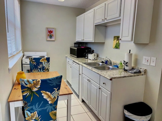 kitchen featuring white cabinets, white appliances, light tile patterned floors, and sink