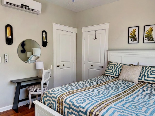 bedroom featuring dark hardwood / wood-style flooring and a wall mounted AC