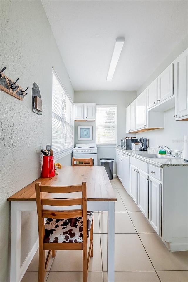 kitchen featuring white appliances, white cabinetry, and kitchen peninsula